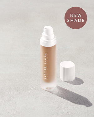 Open bottle of a new shade of Fenty Beauty Pro Filt'r Soft Matte Longwear Foundation with pump dispenser in shade #295 on concrete background