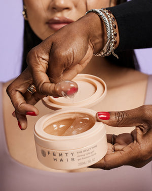 Hair stylist dipping finger into Fenty Hair The Gelly Type Strong Hold Hair Gel hair styler.