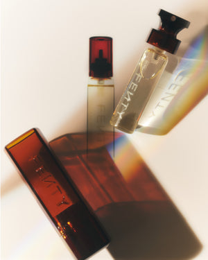Fenty Eau de Parfum bottle and the refill bottle placed against a cream background with their shadows behind them.