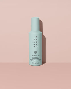 The Water Boi Reparative Leave-In Conditioner Spray on a peach background. The Water Boi Reparative Leave-In Conditioner Spray on a peach background.