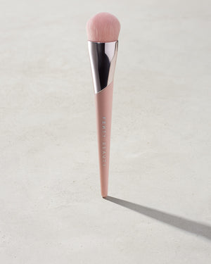 Full-Bodied Foundation Brush 110 standing upright on a concrete backdrop.