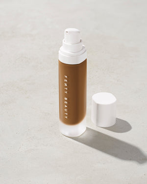 open bottle of Fenty Beauty Pro Filt'r Soft Matte Longwear Foundation with pump dispenser in shade 445 on concrete background