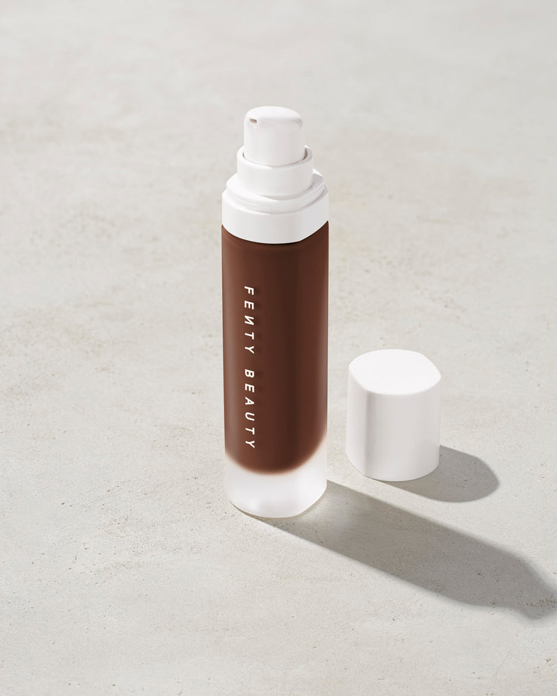open bottle of Fenty Beauty Pro Filt'r Soft Matte Longwear Foundation with pump dispenser in shade 495 on concrete background