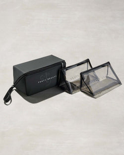 One black rectangular and two triangular clear bags with Fenty branding on a gray background One black rectangular and two triangular clear bags with Fenty branding on a gray background