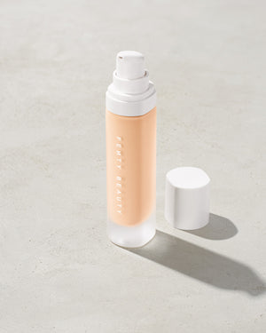 open bottle of Fenty Beauty Pro Filt'r Soft Matte Longwear Foundation with pump dispenser in shade #110 on concrete background