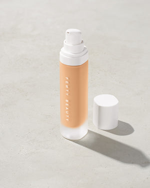 open bottle of Fenty Beauty Pro Filt'r Soft Matte Longwear Foundation with pump dispenser in shade #220 on concrete background