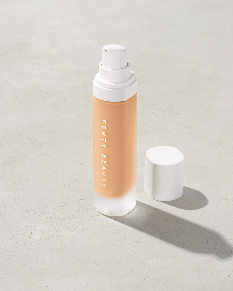 open bottle of Fenty Beauty Pro Filt'r Soft Matte Longwear Foundation with pump dispenser in shade #220 on concrete background