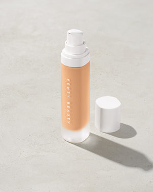 open bottle of Fenty Beauty Pro Filt'r Soft Matte Longwear Foundation with pump dispenser in shade #230 on concrete background