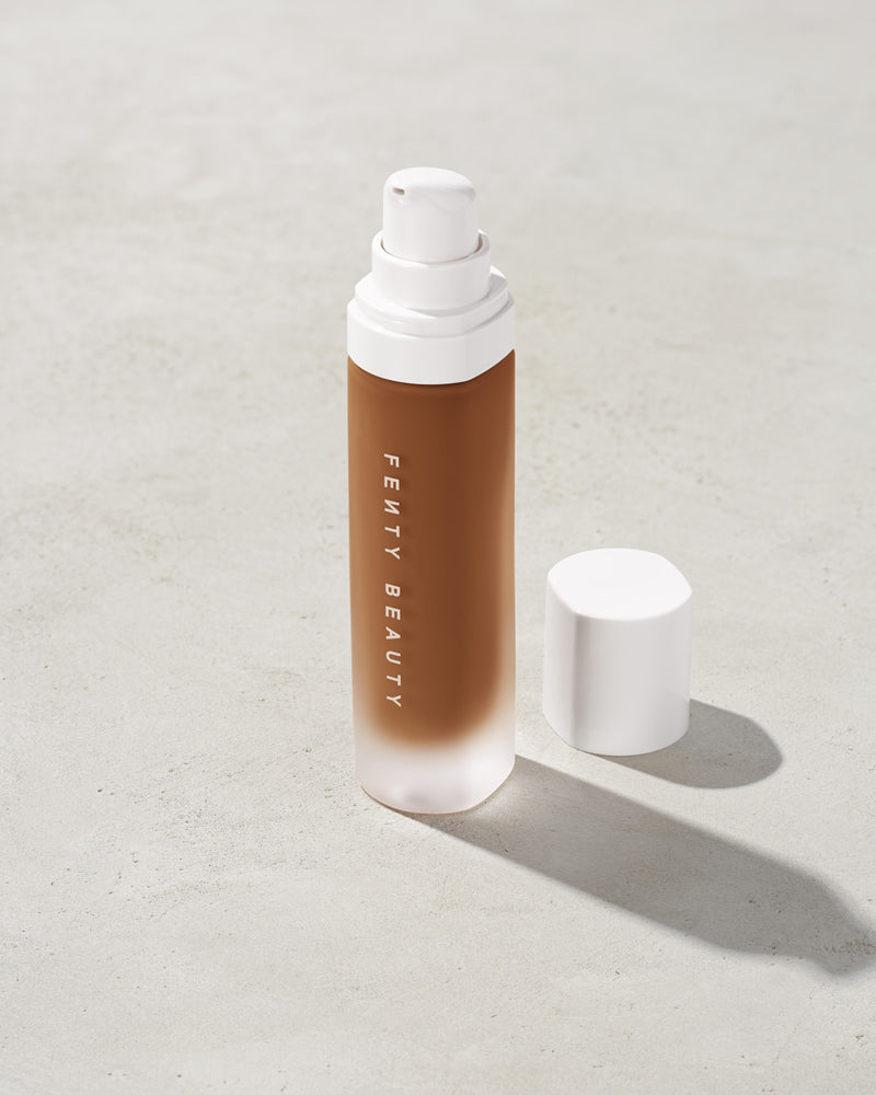 open bottle of Fenty Beauty Pro Filt'r Soft Matte Longwear Foundation with pump dispenser in shade 430 on concrete background