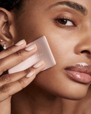 Close-up of model Alex applying Invisimatte Instante Setting Blotting Powder with a sponge