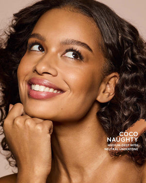 Medium-deep skin tone model wearing sun stalk'r bronzer in shade Coco Naughty.