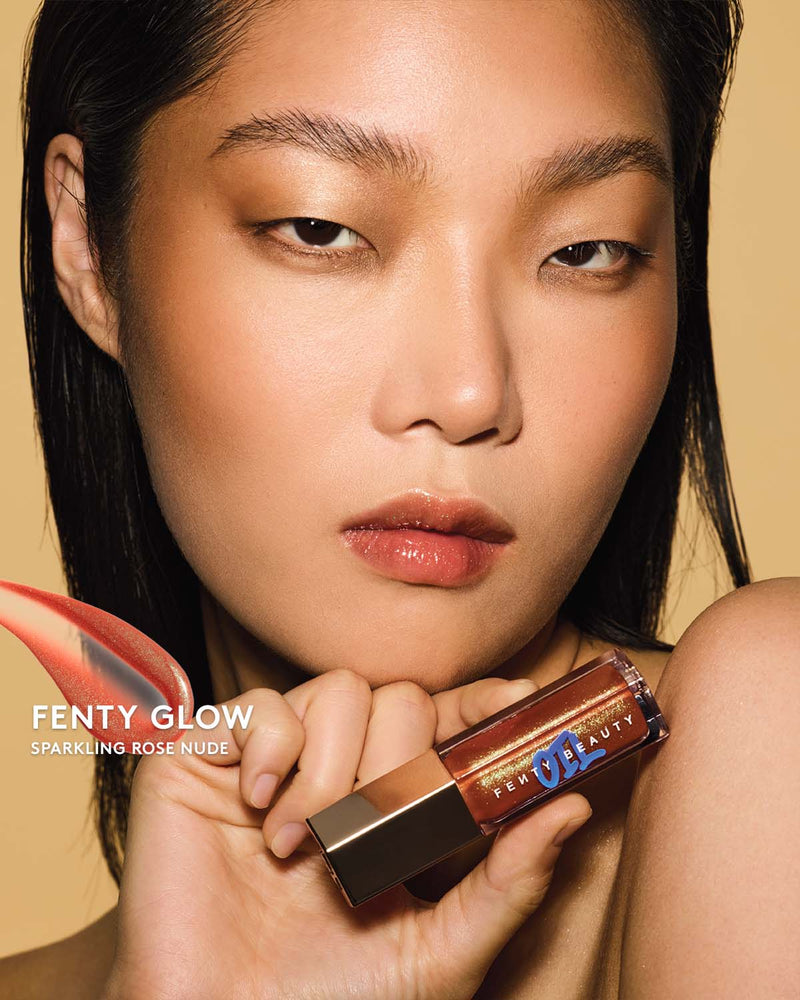 Gloss Bomb Oil Luminizing Oil and  Gloss in shade Fenty Glow on a light skin tone. Fenty Glow is a sparkling rose nude.