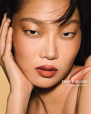 Gloss Bomb Oil Luminizing Oil and  Gloss in shade Fenty Glow on a light skin tone. Fenty Glow is a sparkling rose nude.