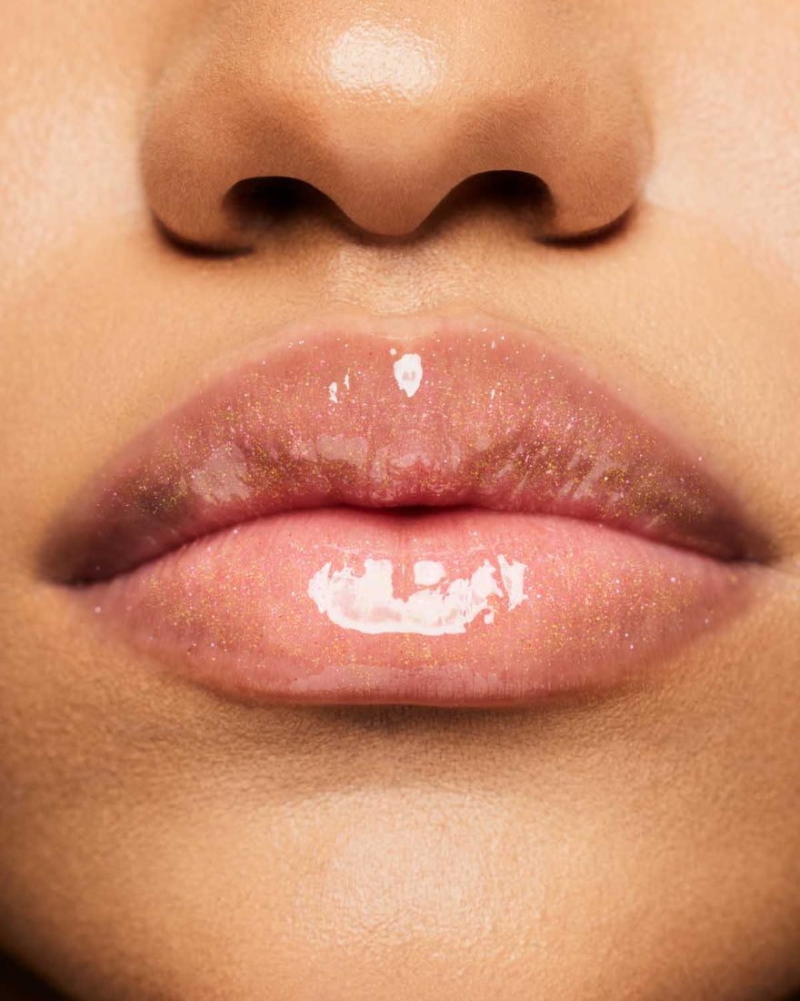 Product shot of Fenty Beauty Gloss Bomb Universal Lip Luminizer and packaging in limited edition Arcane collection shade Rebel Raiser.