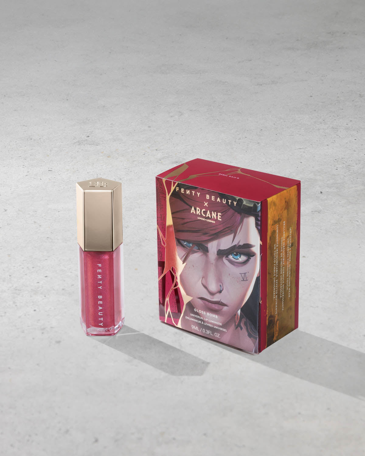 Product shot of Fenty Beauty Gloss Bomb Universal Lip Luminizer and packaging in limited edition Arcane collection shade Rebel Raiser. 