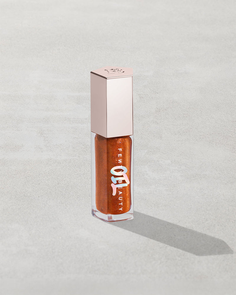 Gloss Bomb Oil Luminizing Oil and  Gloss in shade Frosted Buns product against a concrete background.