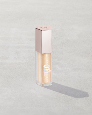 Gloss Bomb Oil Luminizing Oil and  Gloss in shade Supafine Suga product against a concrete background.