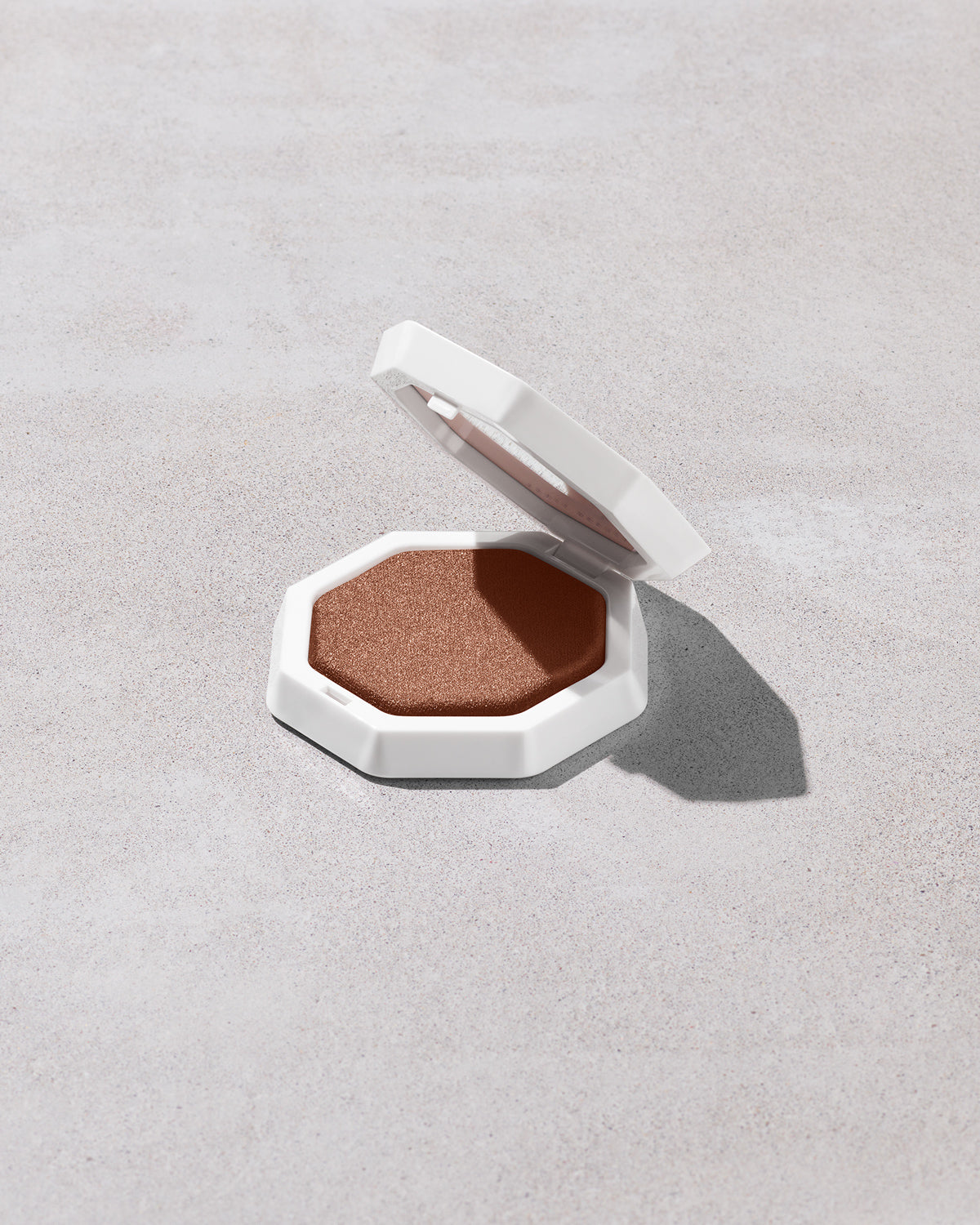 Open product shot of Demi'glow Light-Diffusing Highlighter in shade Java Jitters on a concrete backdrop.