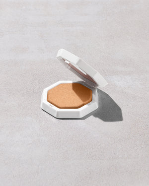 Open product shot of Demi'glow Light-Diffusing Highlighter in shade Loose Change on a concrete backdrop.