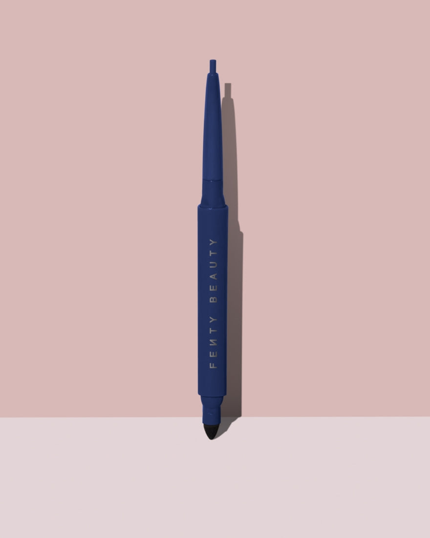 Fine Linez Lash Line-Enhancing Eyeliner in shade 'The Navy' open capped product shot on a two-tone pink background.