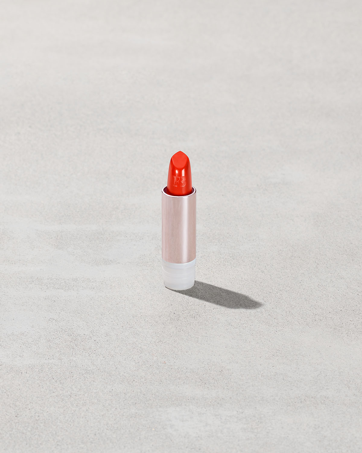 An open Fenty Icon refillable matte lipstick in the high-pigment shade, Nosy Rosy.