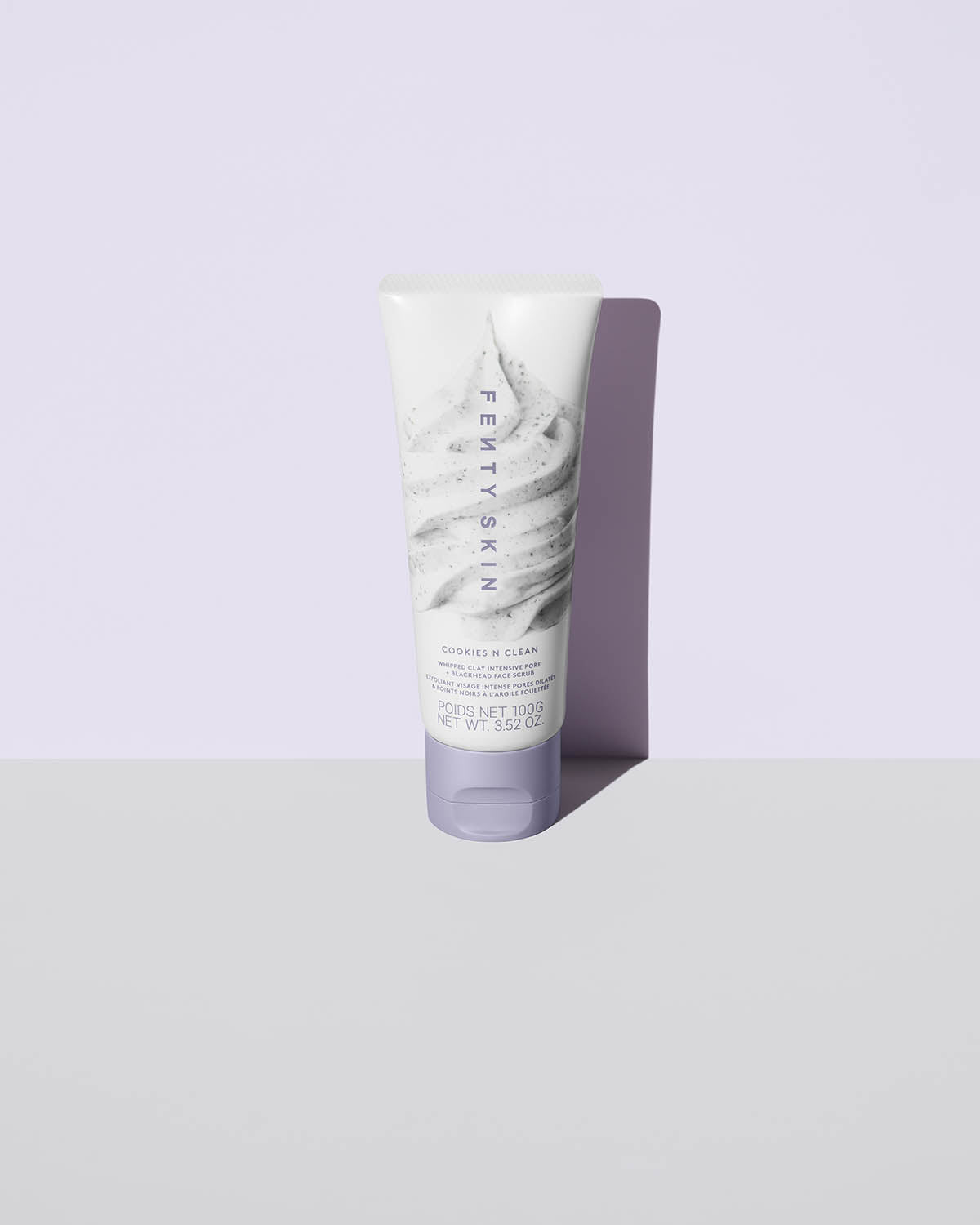 Cookies and clean face scrub product shot on a lavender background.