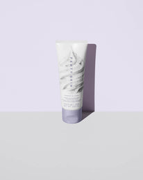 Cookies and clean face scrub product shot on a lavender background.