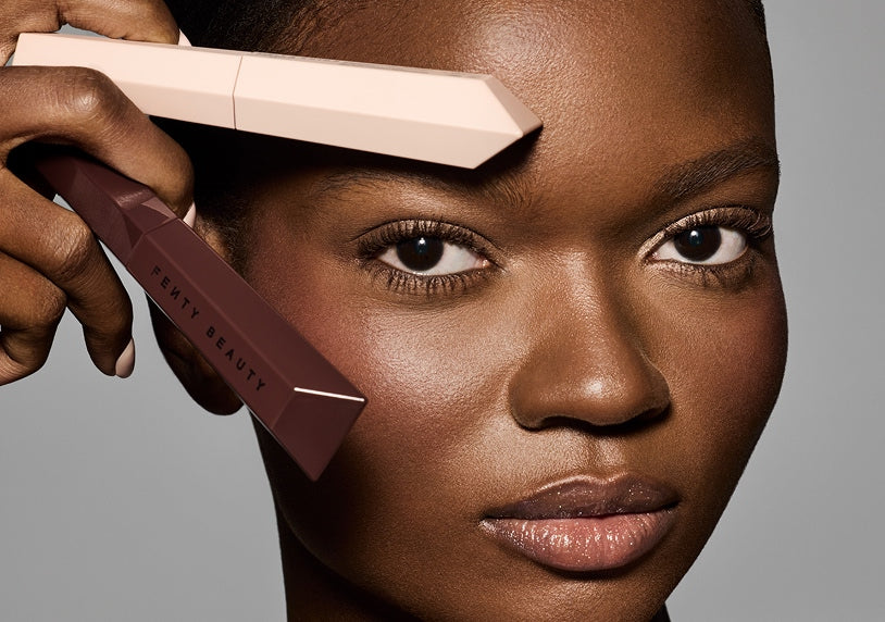 Model holding up new Hella Thicc Mascara in shade 'Lets Be Blunt' and Hella Extra Mascara Primer.