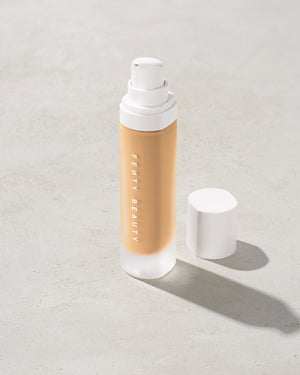open bottle of Fenty Beauty Pro Filt'r Soft Matte Longwear Foundation with pump dispenser in shade #235 on concrete background