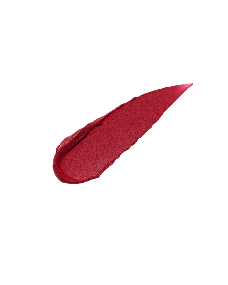 A smear of Fenty Icon Velvet lipstick in red color on a translucent background.