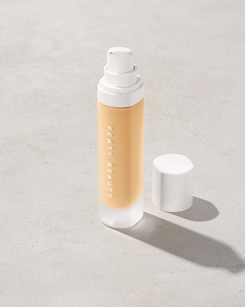 open bottle of Fenty Beauty Pro Filt'r Soft Matte Longwear Foundation with pump dispenser in shade #130 on concrete background
