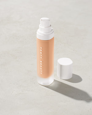 open bottle of Fenty Beauty Pro Filt'r Soft Matte Longwear Foundation with pump dispenser in shade #170 on concrete background