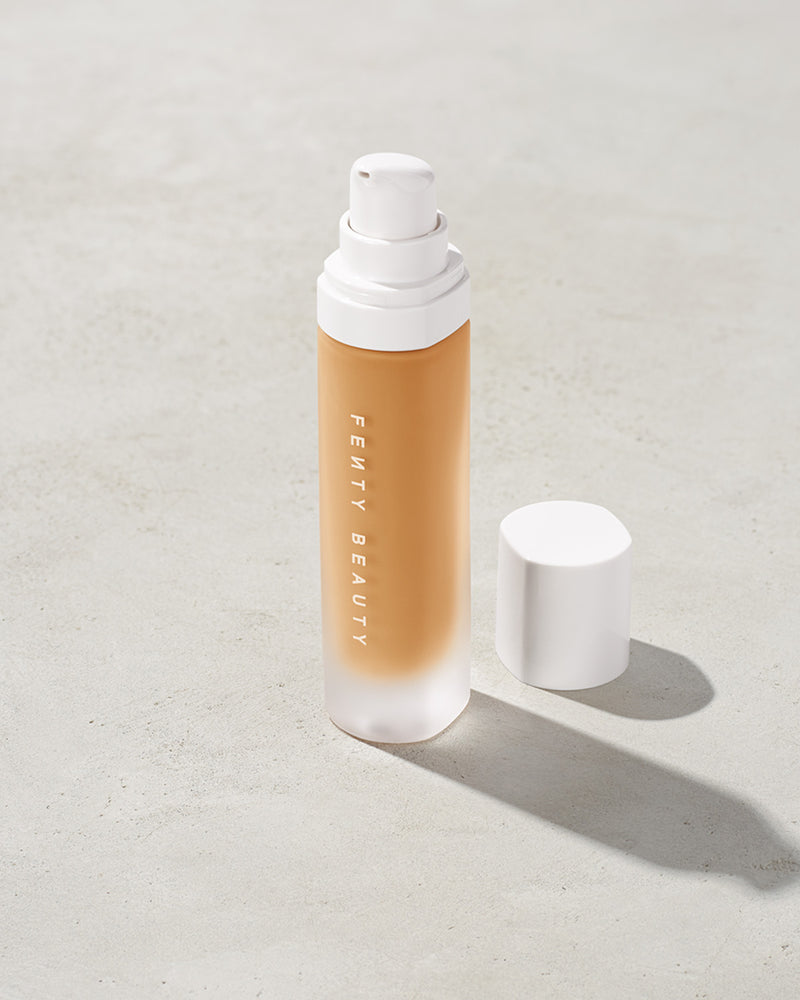 open bottle of Fenty Beauty Pro Filt'r Soft Matte Longwear Foundation with pump dispenser in shade 300 on concrete background