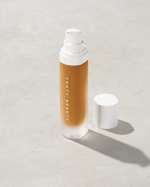 open bottle of Fenty Beauty Pro Filt'r Soft Matte Longwear Foundation with pump dispenser in shade 350 on concrete background