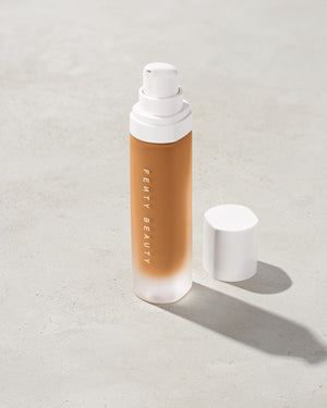 open bottle of Fenty Beauty Pro Filt'r Soft Matte Longwear Foundation with pump dispenser in shade 390 on concrete background