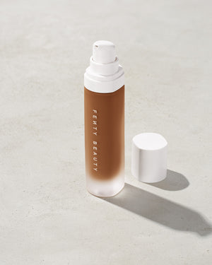 open bottle of Fenty Beauty Pro Filt'r Soft Matte Longwear Foundation with pump dispenser in shade 430 on concrete background