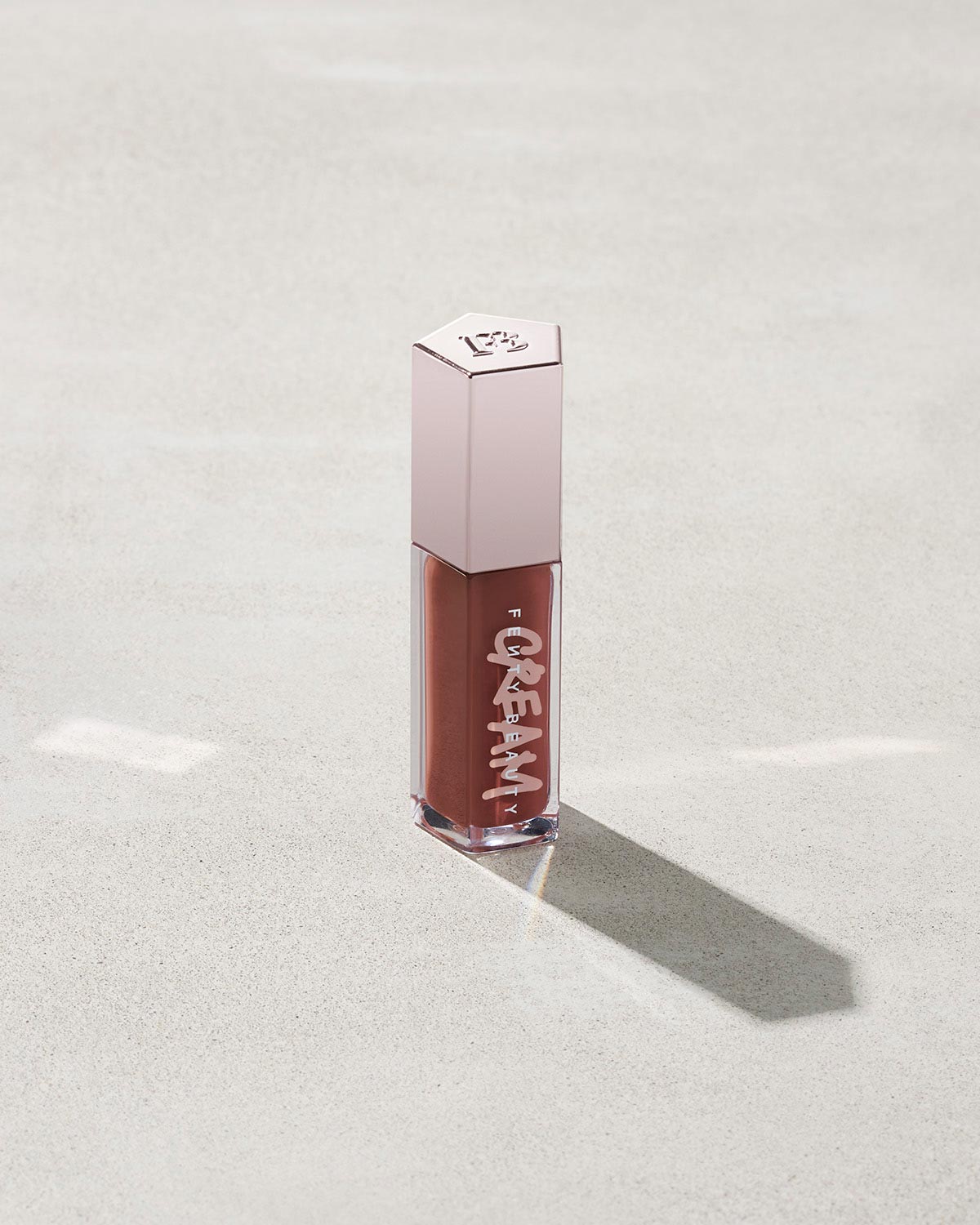 tube of Fenty Beauty Gloss Bomb Cream Color Drip Lip Cream lip gloss shown in shade Cookie Jar