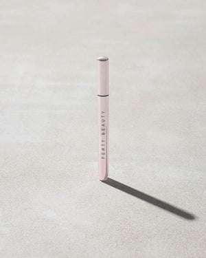 Closed Flyliner Longwear Liquid Eyeliner standing on a light grey concrete surface. The exterior showcases a chic light metallic pink finish.