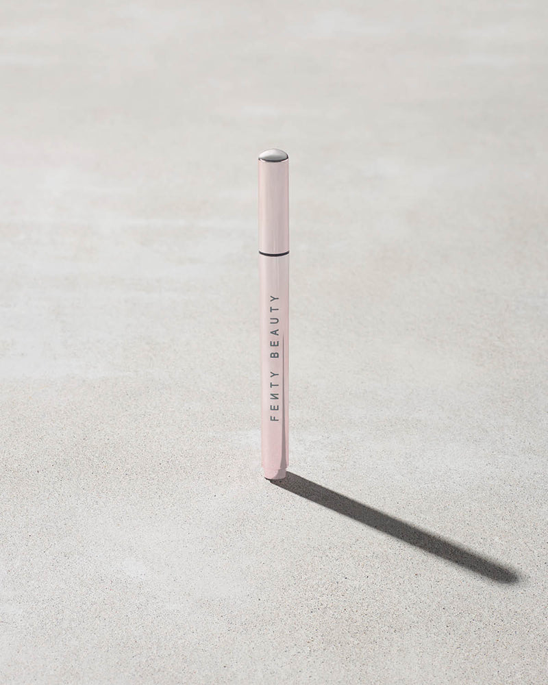 Closed Flyliner Longwear Liquid Eyeliner standing on a light grey concrete surface. The exterior showcases a chic light metallic pink finish.