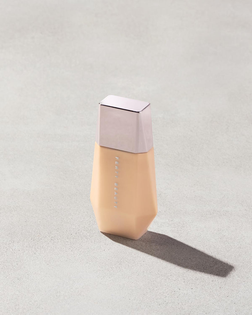 Eaze Drop’Lit All-Over Glow Enhancer shown in shade Taffy Topaz on a concrete background. 