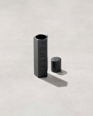 An open Fenty Icon refillable lipstack case in matte black.