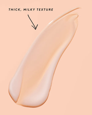 smear of fat water on a peach background noting its thick, milky texture