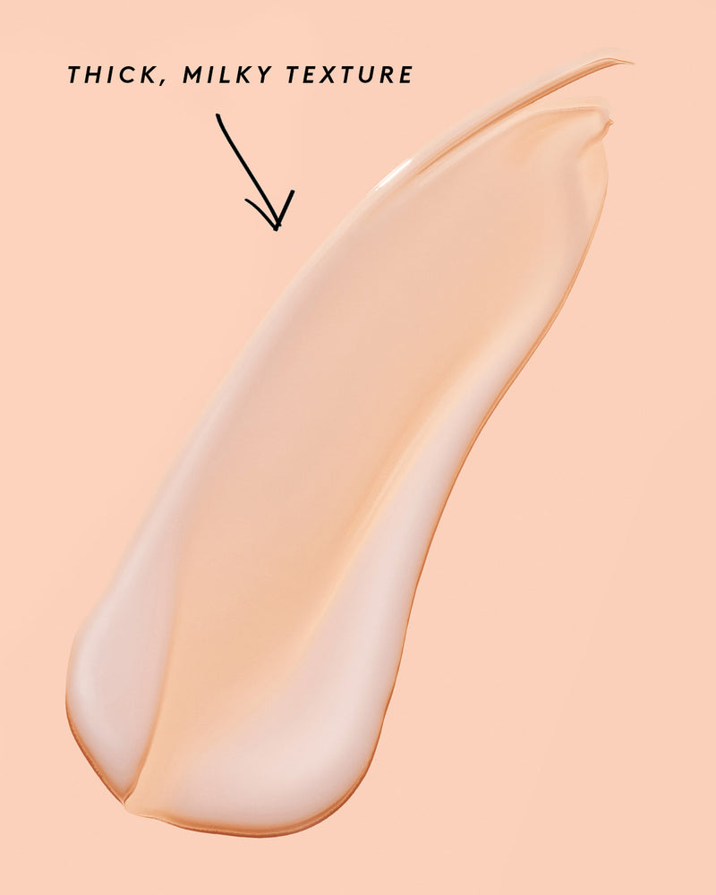 smear of fat water on a peach background noting its thick, milky texture